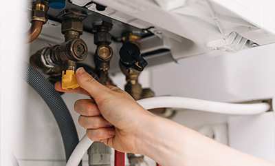 hand adjusting a valve in a plumbing system featuring various pipes and connectors essential for water flow maintenance for home improvement projects with 21st century solutions