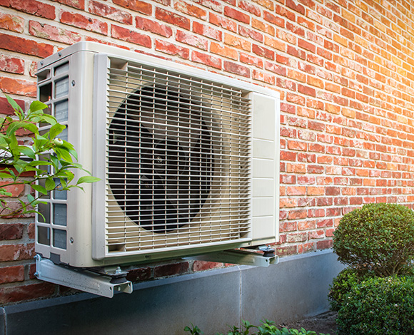 air conditioning unit mounted on a brick wall with greenery and landscaping featuring 14 efficiency ratings